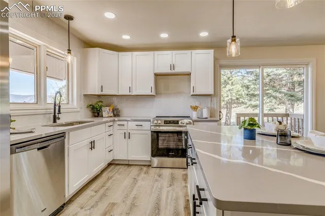 a kitchen with stainless steel appliances granite countertop sink stove top oven and cabinets