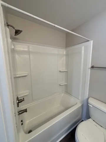 a bathroom with a toilet and a bath tub