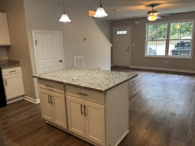 a kitchen with a sink window and wooden floor