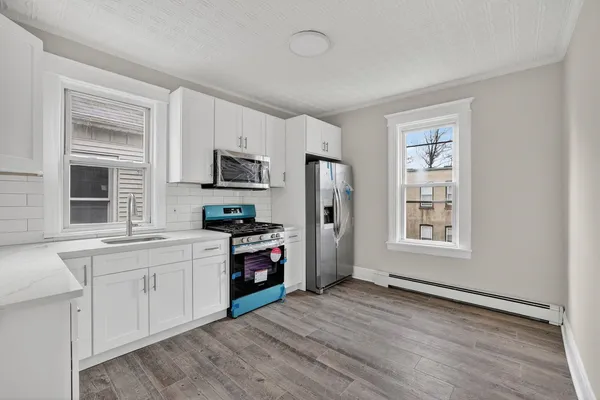 a kitchen with stainless steel appliances a stove a sink refrigerator and a window