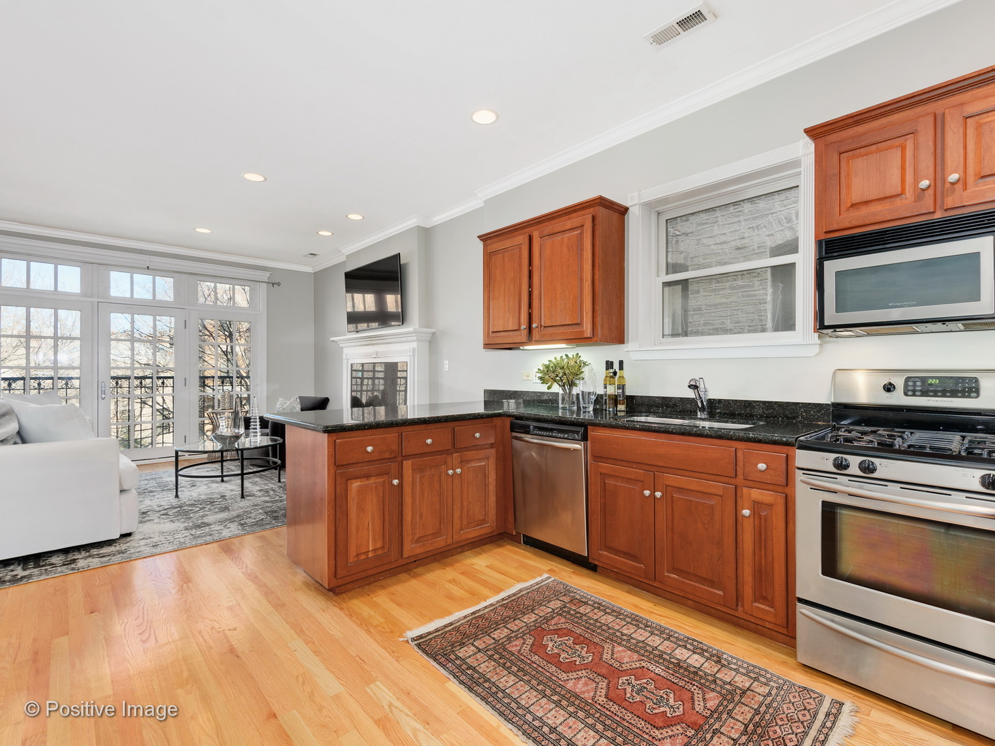 1908 North Sheffield Avenue, Unit 2 Chicago, IL 60614 - Photo 9 of 17 a kitchen with stainless steel appliances granite countertop a stove a sink dishwasher a microwave oven and a dining table with wooden cabinet