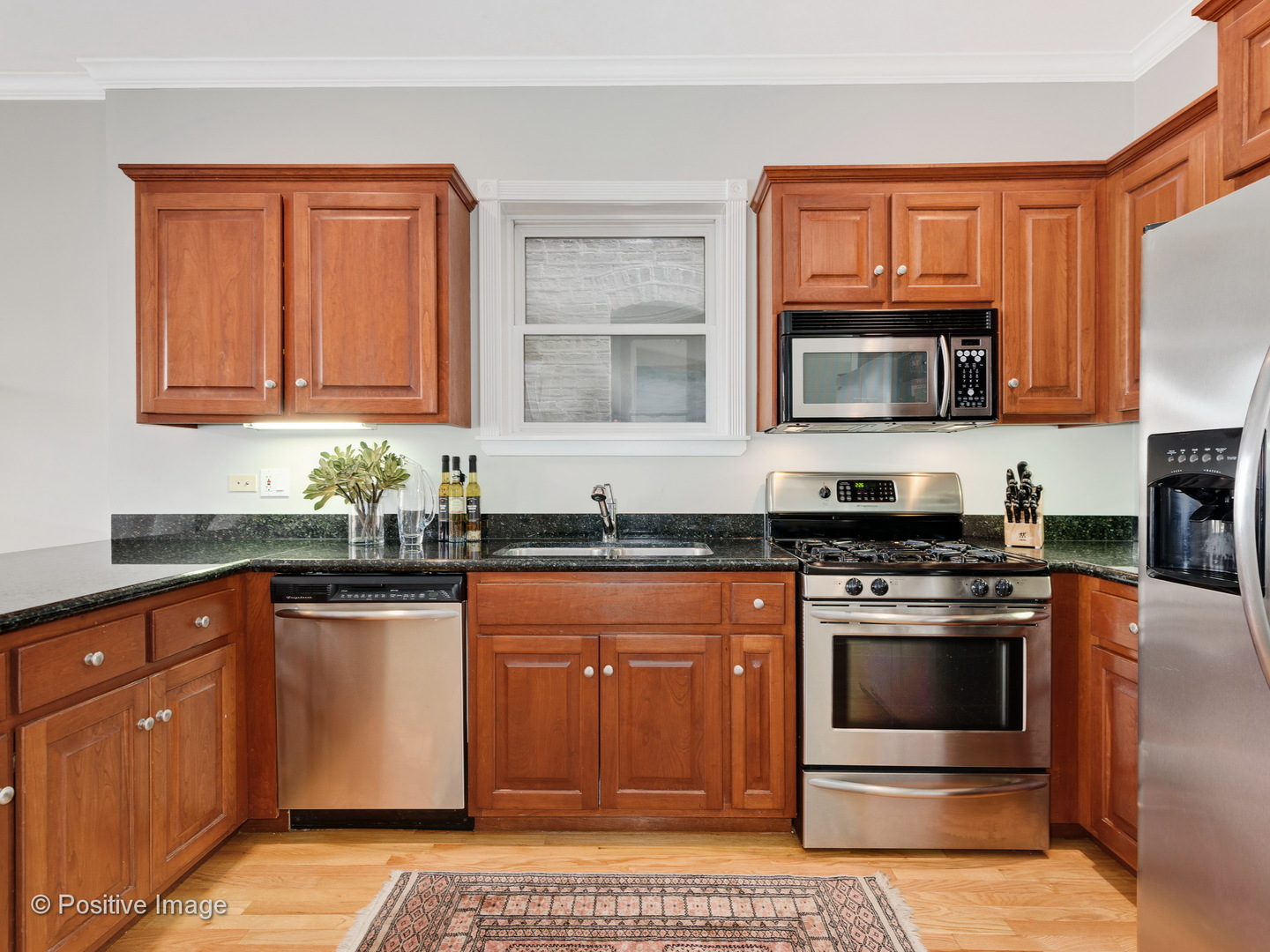 1908 North Sheffield Avenue, Unit 2 Chicago, IL 60614 - Photo 10 of 17 a kitchen with granite countertop a stove top oven microwave and cabinets