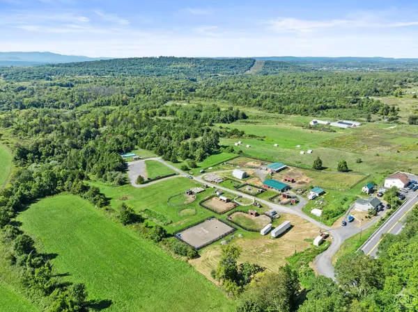 an aerial view of residential houses with outdoor space and trees