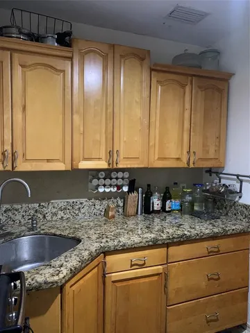 a kitchen with granite countertop a sink a stove and cabinets