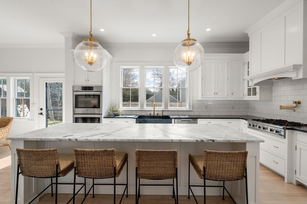 11 Fisher Avenue Wellesley, MA 02482 - Photo 7 of 35 a kitchen with stainless steel appliances granite countertop a stove a sink a counter space a dining table and chairs with wooden floor