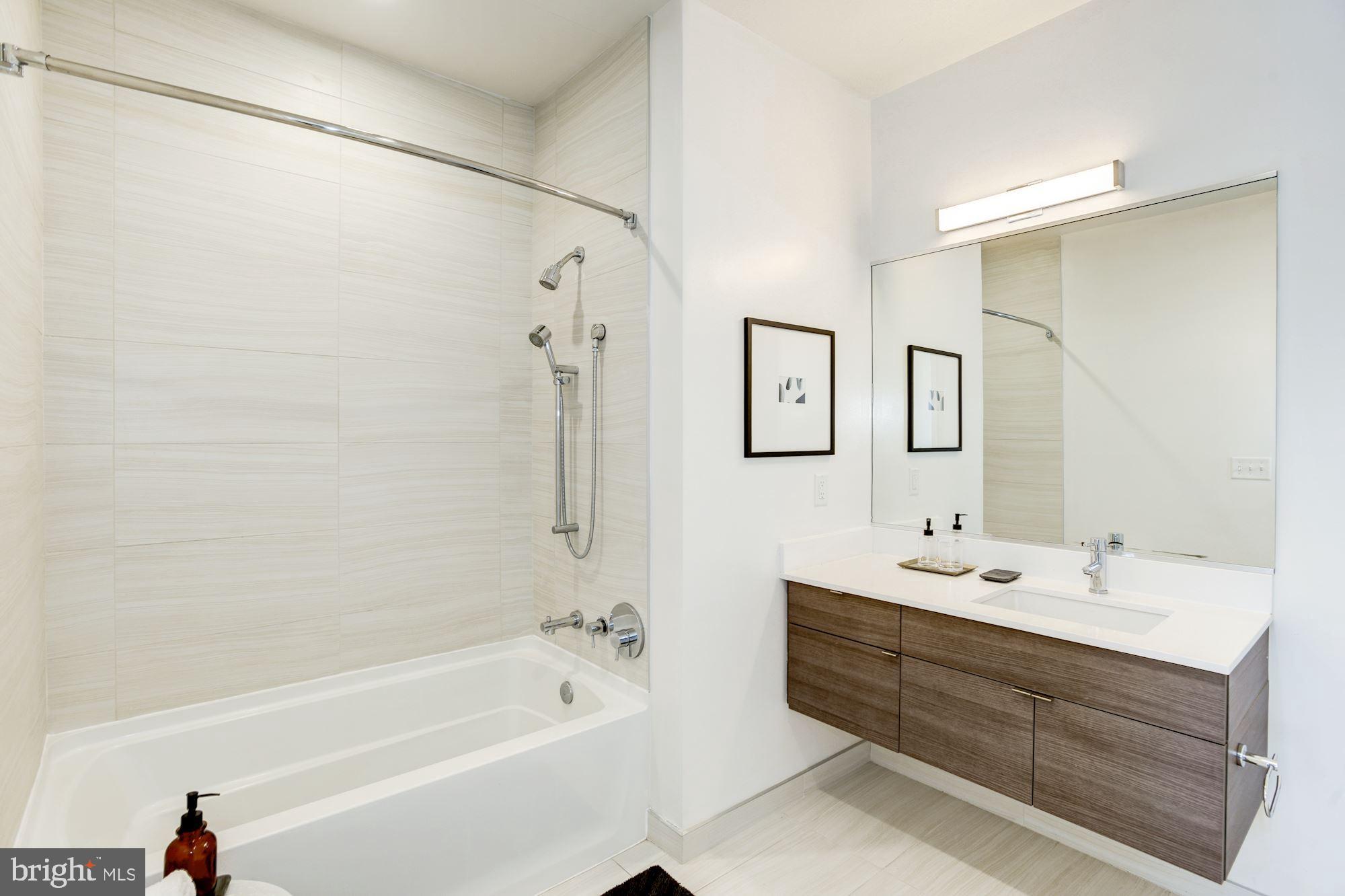 1550 11th Street Northwest, Unit 307 Washington, DC 20005 - Photo 11 of 22 a bathroom with a double vanity sink mirror double and bathtub