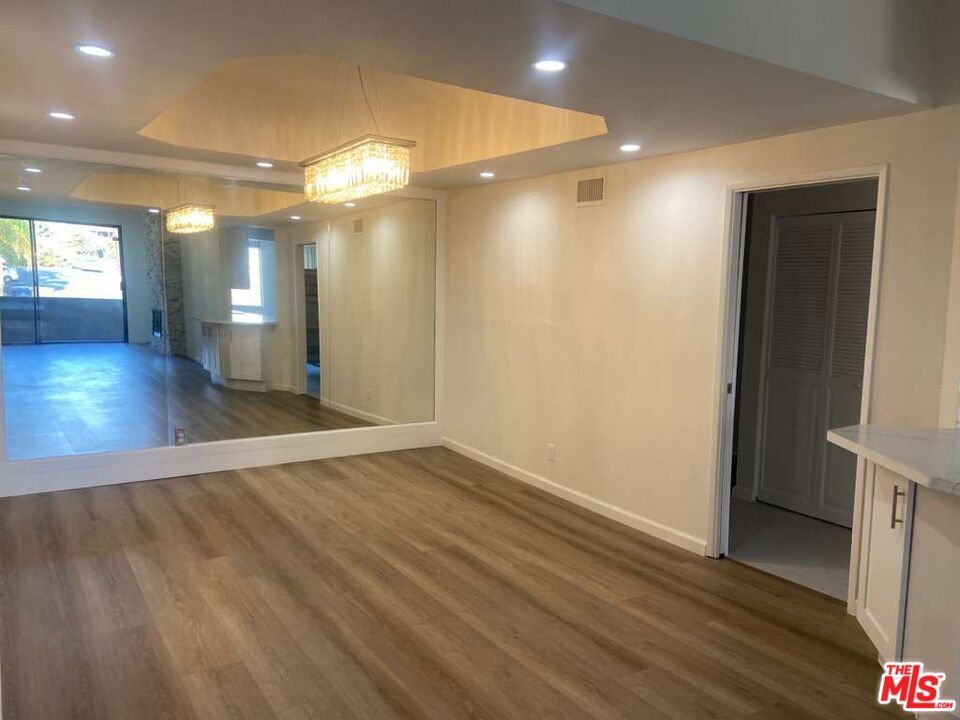 1557 South Beverly Glen Boulevard, Unit 104 Los Angeles, CA 90024 - Photo 11 of 44 wooden floor in an empty room with a window