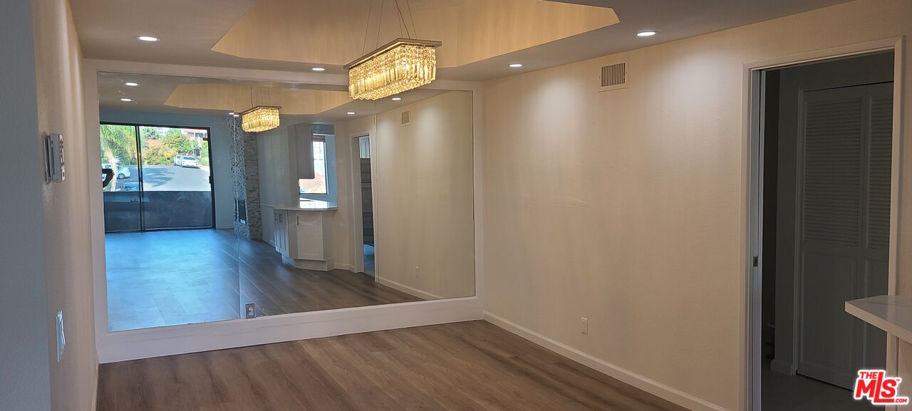 1557 South Beverly Glen Boulevard, Unit 104 Los Angeles, CA 90024 - Photo 13 of 44 wooden floor in an empty room with a mirror