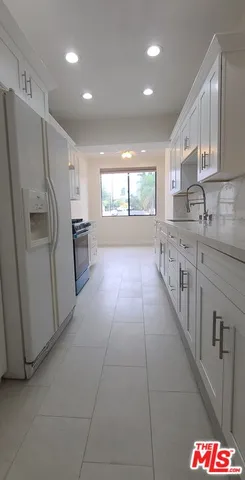 a kitchen with granite countertop white cabinets and window