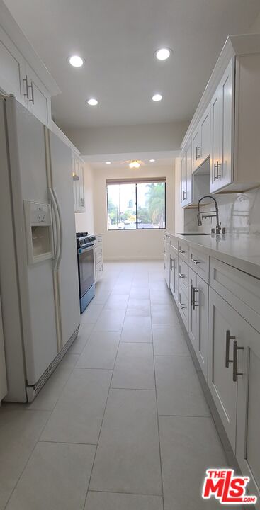 1557 South Beverly Glen Boulevard, Unit 104 Los Angeles, CA 90024 - Photo 19 of 44 a kitchen with refrigerator and window