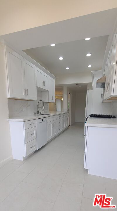 1557 South Beverly Glen Boulevard, Unit 104 Los Angeles, CA 90024 - Photo 21 of 44 a large kitchen with stainless steel appliances lots of counter top space