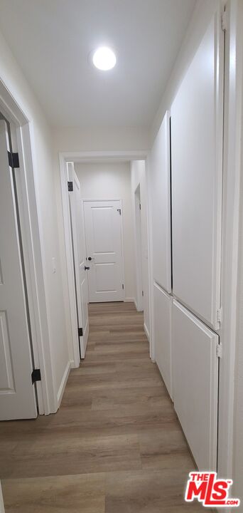 1557 South Beverly Glen Boulevard, Unit 104 Los Angeles, CA 90024 - Photo 25 of 44 a view of a hallway with wooden floor and staircase
