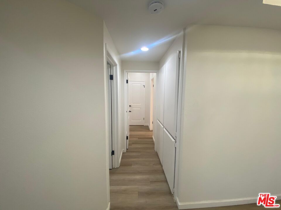 1557 South Beverly Glen Boulevard, Unit 104 Los Angeles, CA 90024 - Photo 26 of 44 a view of a hallway with wooden floor and staircase