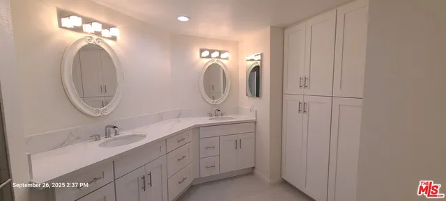 a en suite bathroom with a double vanity sink and a mirror