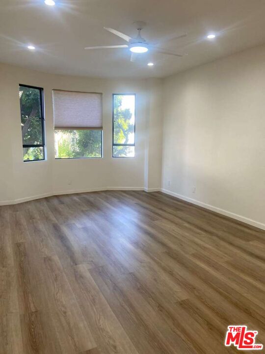 1557 South Beverly Glen Boulevard, Unit 104 Los Angeles, CA 90024 - Photo 33 of 44 an empty room with wooden floor and windows