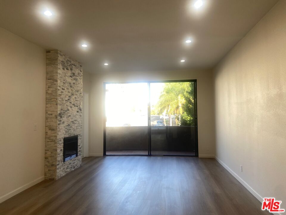 1557 South Beverly Glen Boulevard, Unit 104 Los Angeles, CA 90024 - Photo 5 of 44 an empty room with wooden floor and windows