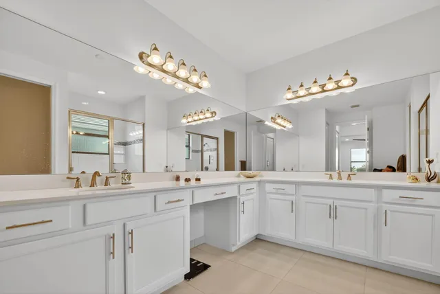 a large white kitchen with a sink and dishwasher with white cabinets
