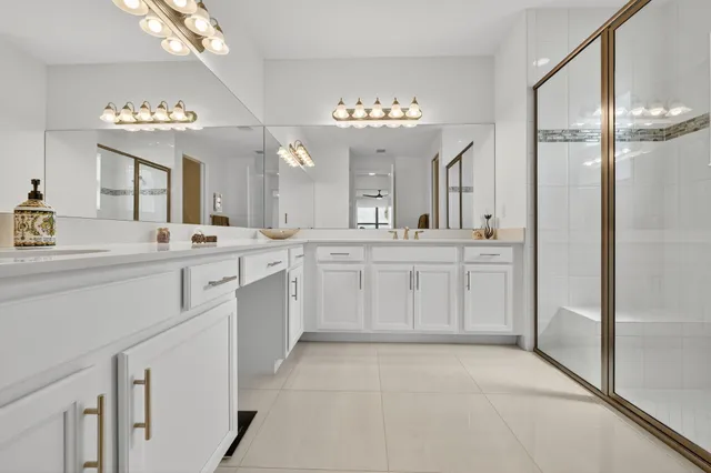 a large white kitchen with cabinets a sink and stainless steel appliances