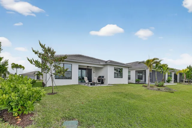 a view of house with yard and outdoor seating