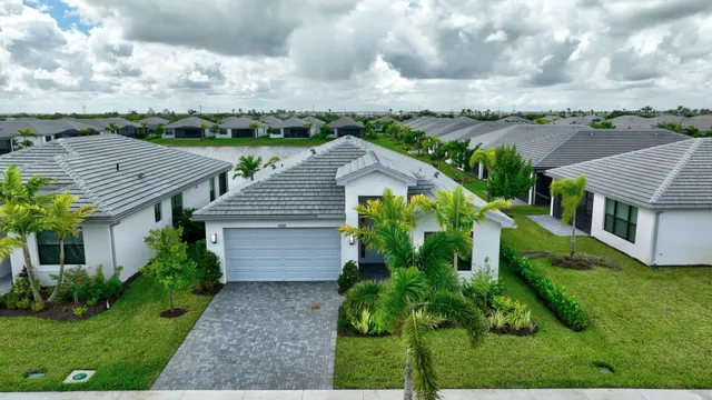 a view of a house with a yard and potted plants