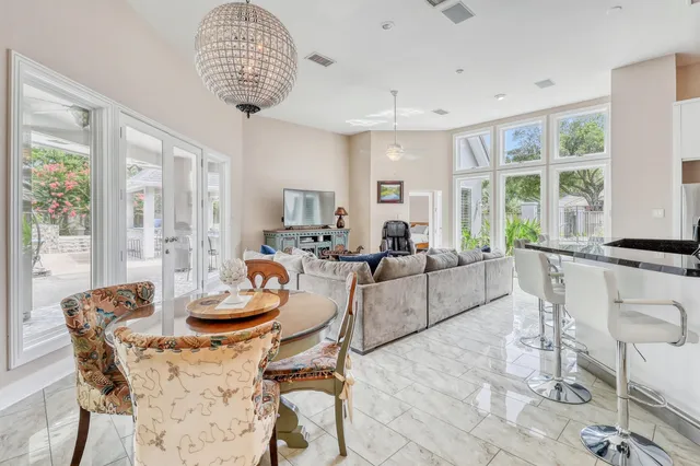 a dining room with furniture a chandelier and wooden floor