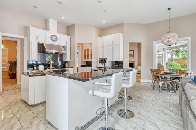 a very nice looking open dining room with kitchen island stainless steel appliances a table and chairs