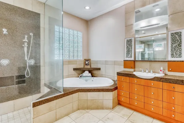 a spacious bathroom with a granite countertop sink mirror and bathtub