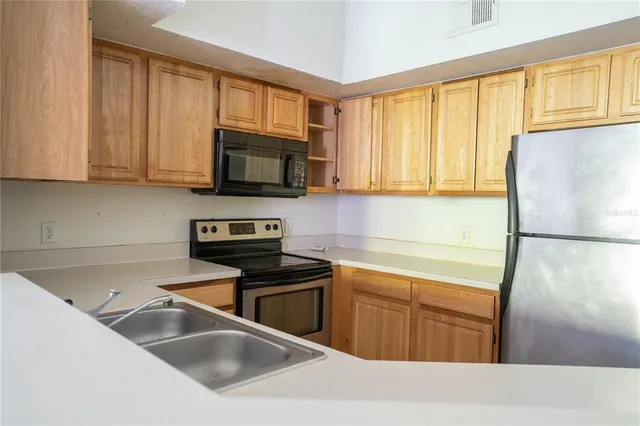 a kitchen with a sink a stove and a microwave