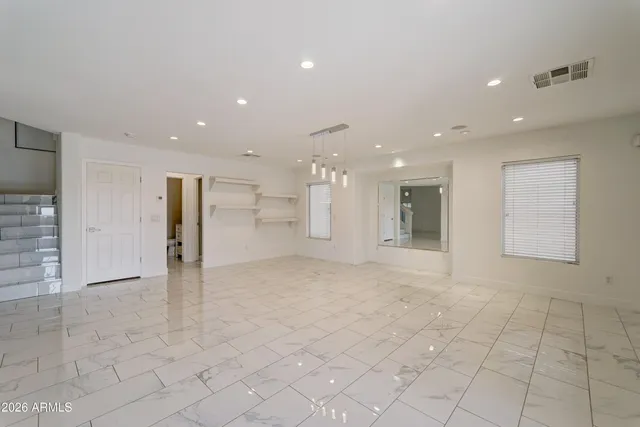 an empty room with windows and fan