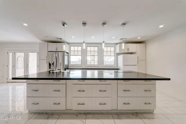 a kitchen with granite countertop white cabinets and sink