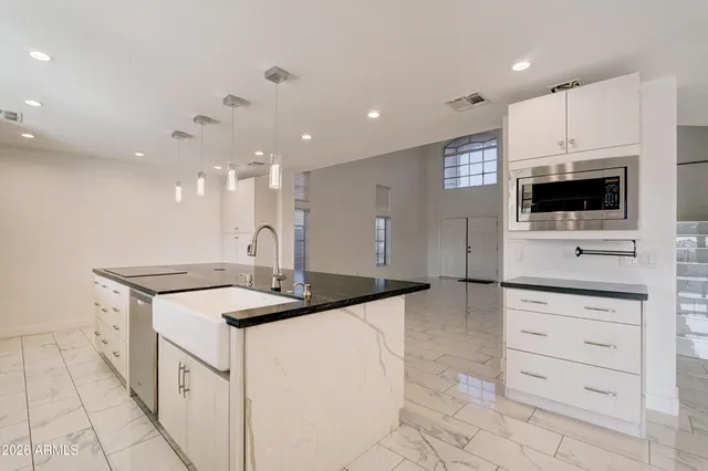 a kitchen with a sink and a stove top oven with wooden floor