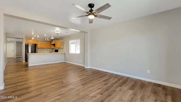 a view of empty room with wooden floor and a ceiling fan