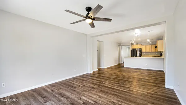 an empty room with a window and ceiling fan