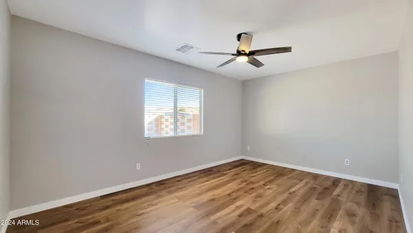 a view of a room with wooden floor stairs and a ceiling fan