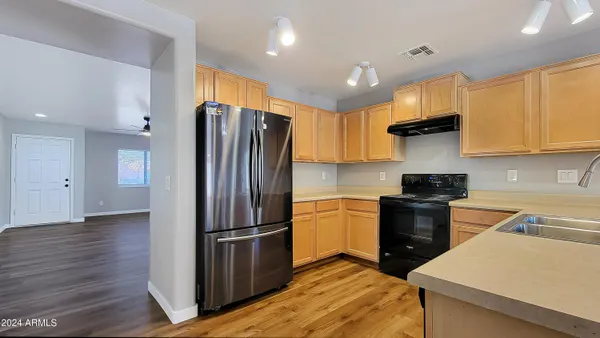 a kitchen with granite countertop a refrigerator and a stove top oven