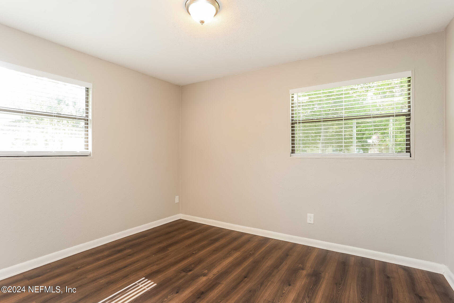 7003 Rollo Road Jacksonville, FL 32205 - Photo 13 of 21 an empty room with wooden floor and windows