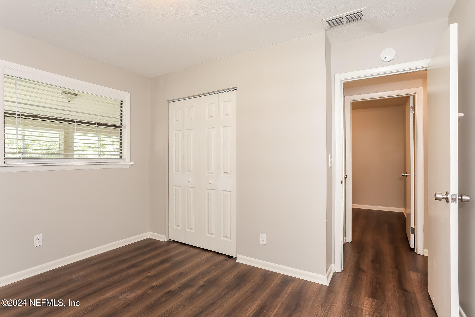 7003 Rollo Road Jacksonville, FL 32205 - Photo 16 of 21 a view of an empty room with wooden floor and a window