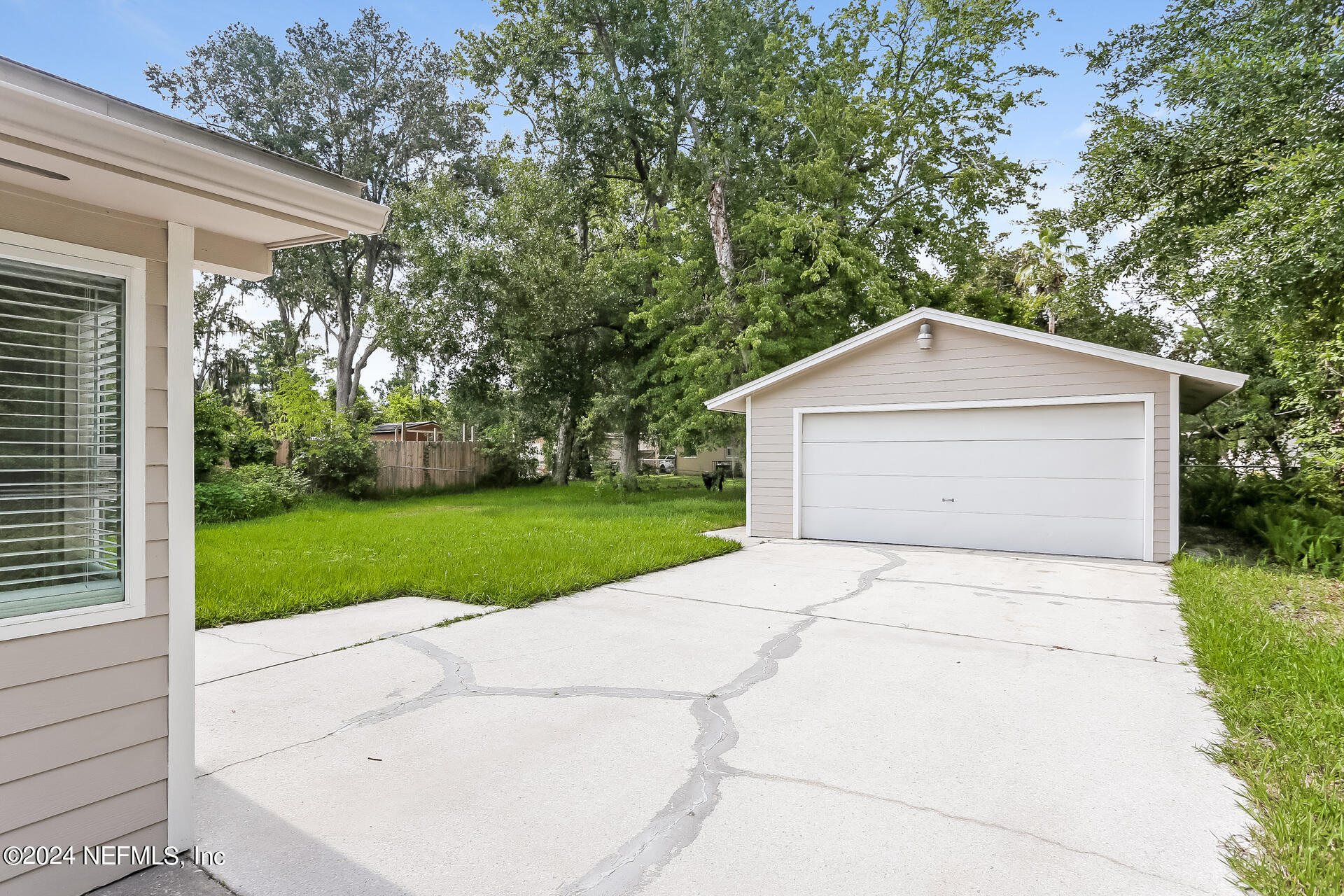 7003 Rollo Road Jacksonville, FL 32205 - Photo 20 of 21 a white house with a small yard plants and large trees
