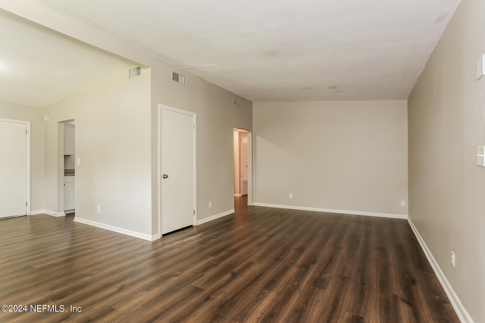 7003 Rollo Road Jacksonville, FL 32205 - Photo 3 of 21 a view of an empty room with wooden floor