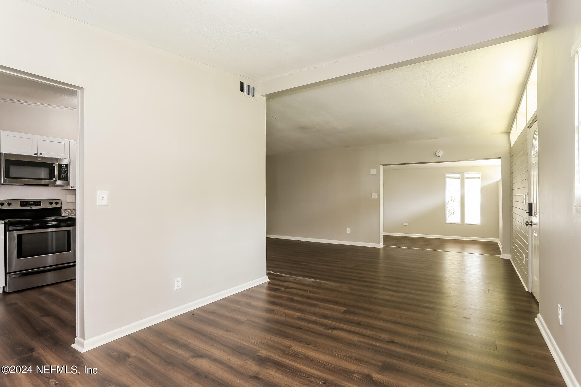 7003 Rollo Road Jacksonville, FL 32205 - Photo 5 of 21 a view of an empty room with wooden floor and a window
