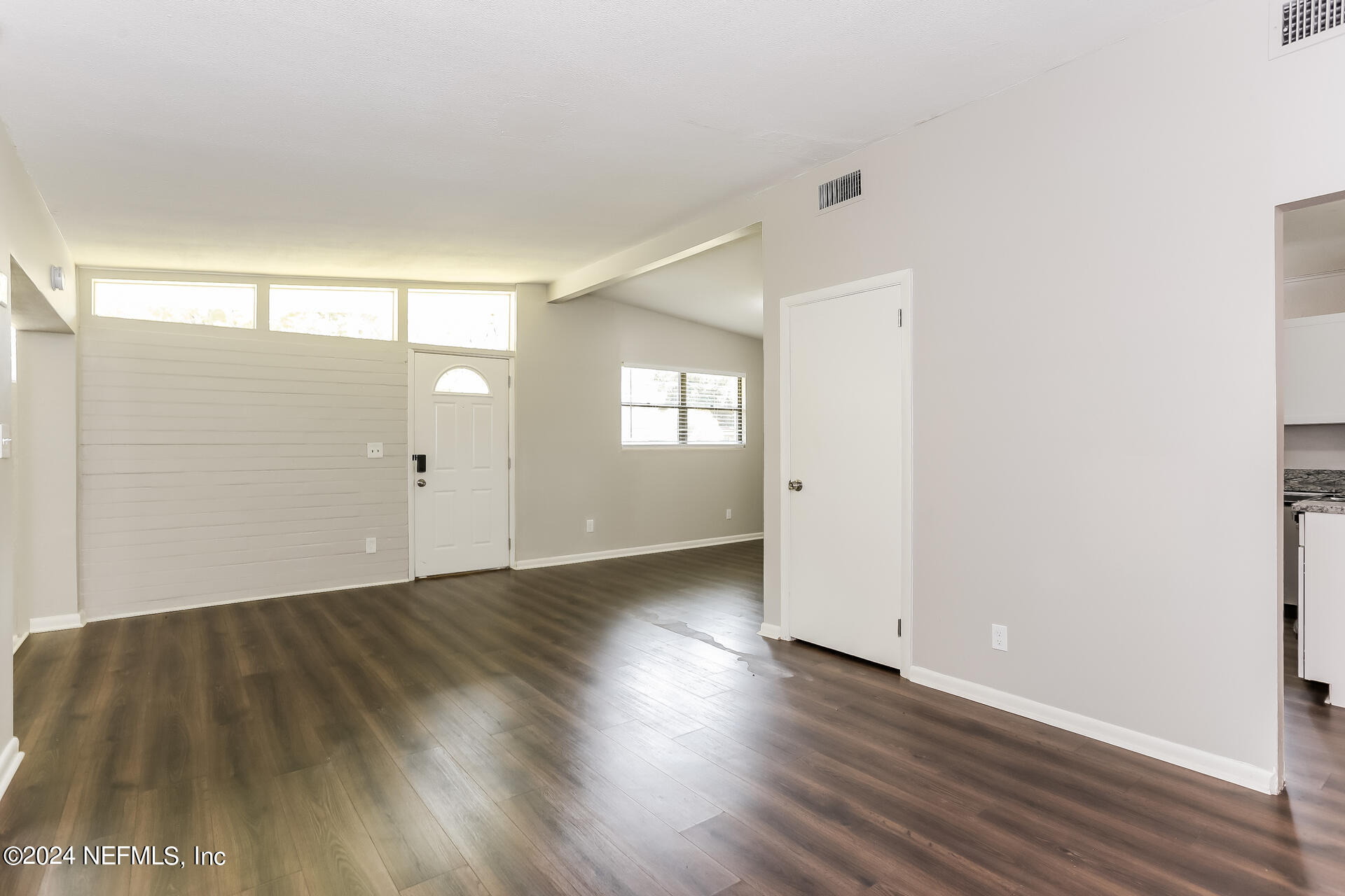 7003 Rollo Road Jacksonville, FL 32205 - Photo 6 of 21 an empty room with wooden floor and windows