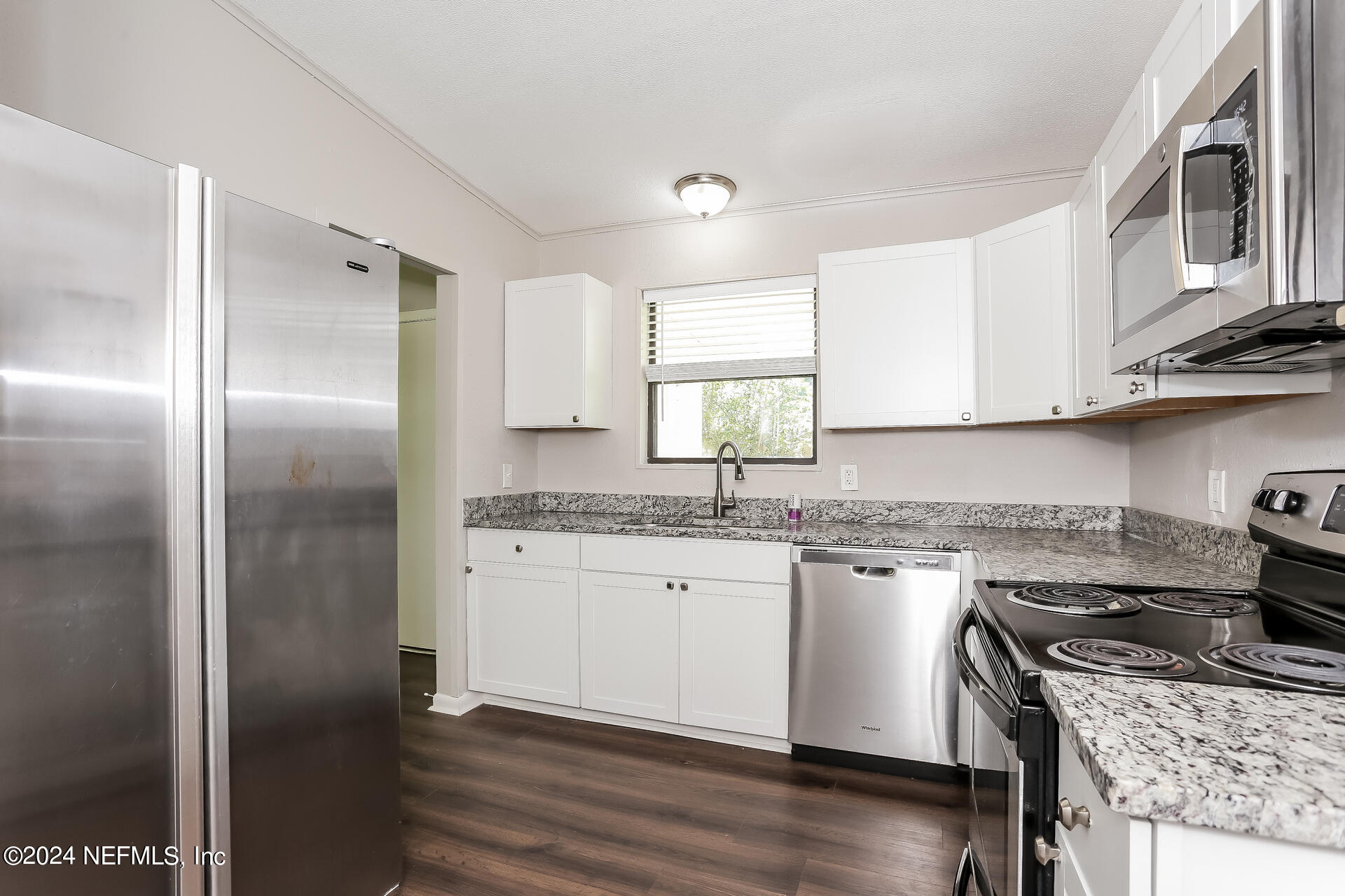 7003 Rollo Road Jacksonville, FL 32205 - Photo 7 of 21 a kitchen with stainless steel appliances granite countertop a stove a sink and a refrigerator