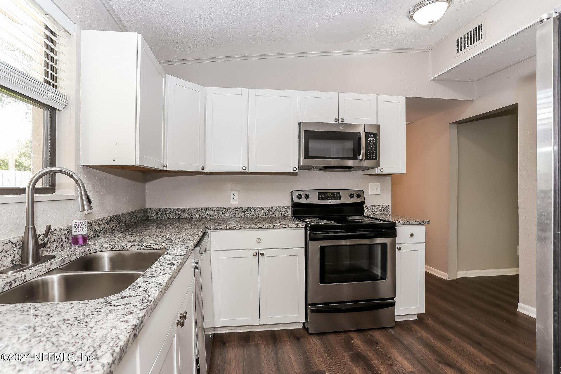 7003 Rollo Road Jacksonville, FL 32205 - Photo 8 of 21 a kitchen with granite countertop a sink and a stove top oven