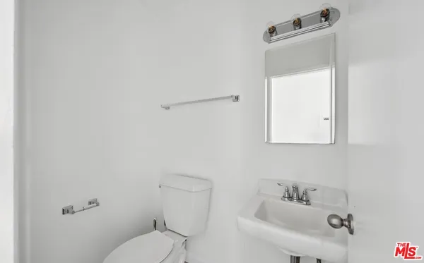 a white toilet sitting next to a bathroom sink