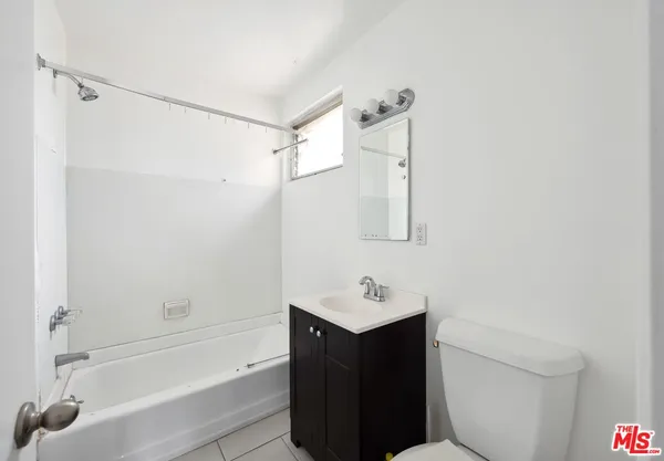 a bathroom with a bathtub shower sink vanity and toilet