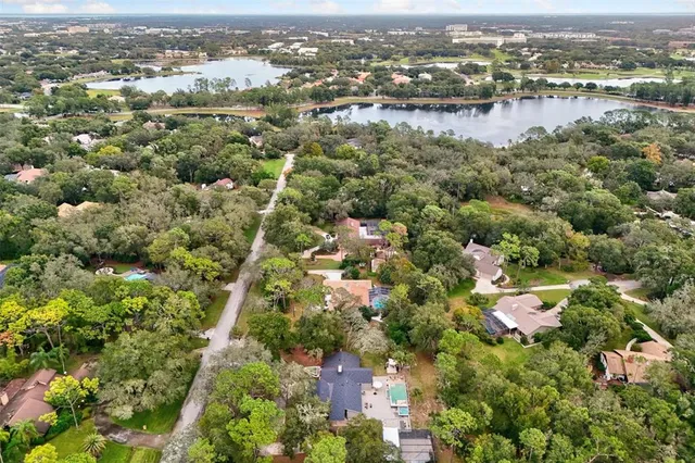 an aerial view of residential houses with outdoor space and lake view