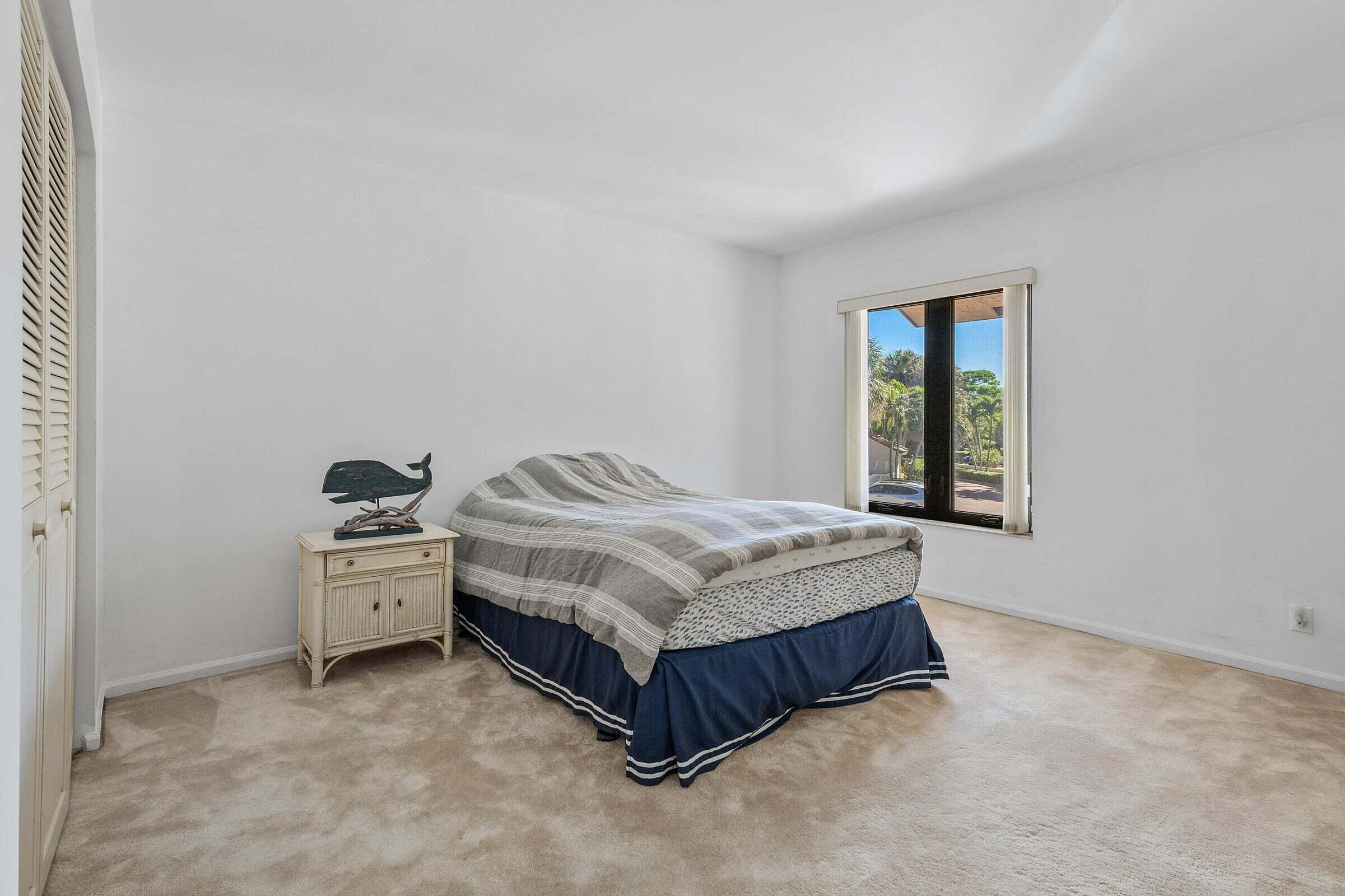 6711 North Ocean Boulevard, Unit 13 Ocean Ridge, FL 33435 - Photo 30 of 50 a spacious bedroom with a bed and window