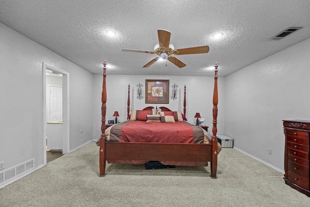 6939 Calender Road Arlington, TX 76001 - Photo 11 of 40 Bedroom with a textured ceiling, carpet floors, a ceiling fan, and baseboards