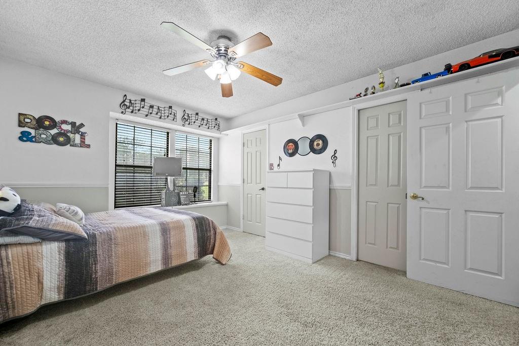 6939 Calender Road Arlington, TX 76001 - Photo 12 of 40 Bedroom featuring carpet floors, a textured ceiling, and ceiling fan