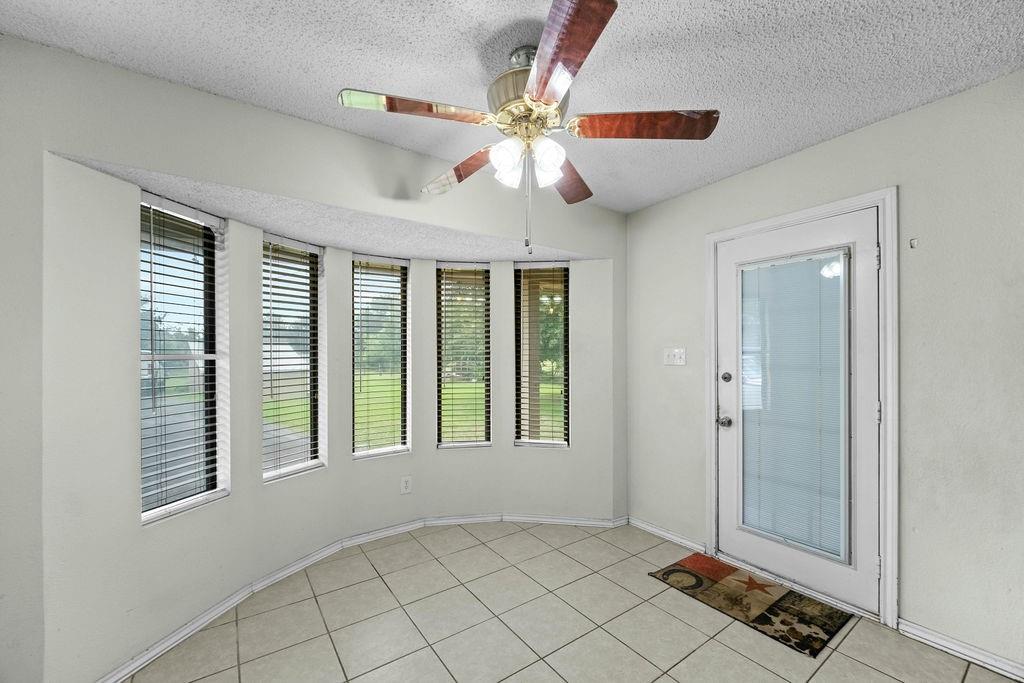 6939 Calender Road Arlington, TX 76001 - Photo 21 of 40 Entrance foyer featuring a textured ceiling, ceiling fan, baseboards, and light tile patterned floors